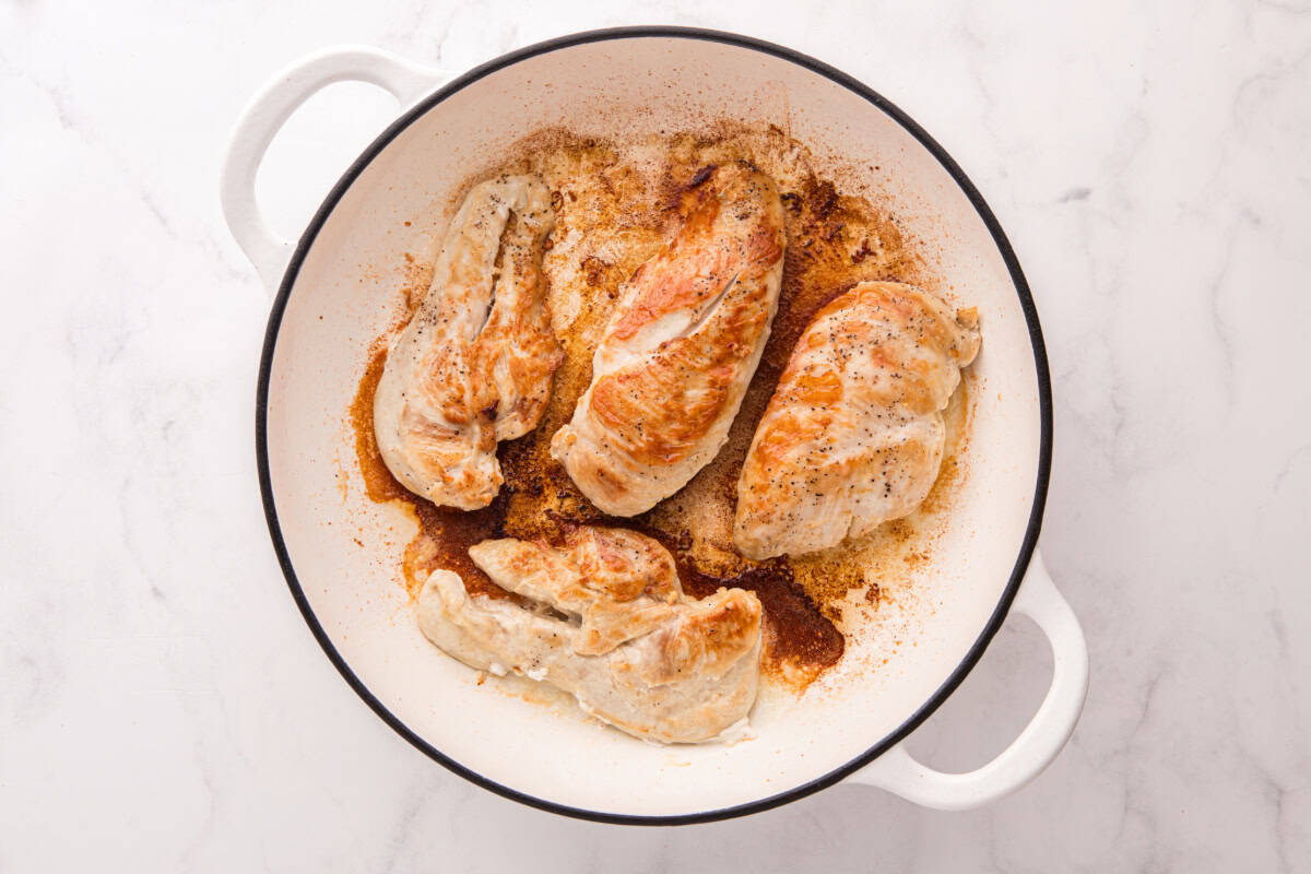 Browned chicken breasts in a skillet.