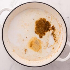Coconut milk and seasonings added to the skillet.