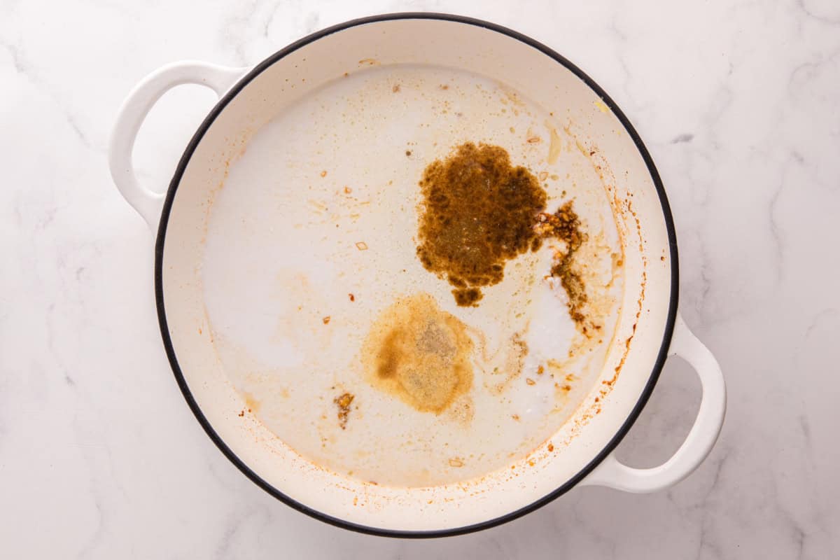 Coconut milk and seasonings added to the skillet.