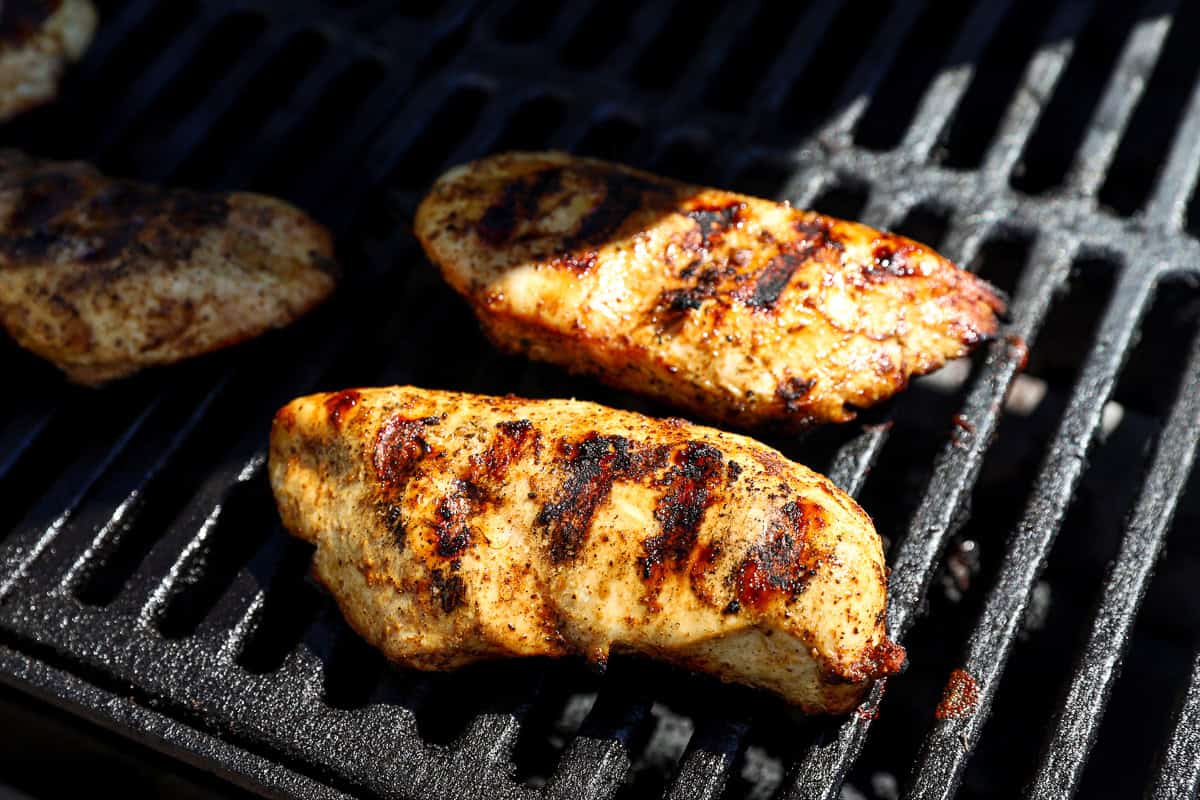 Cooked chicken breasts on a grill.