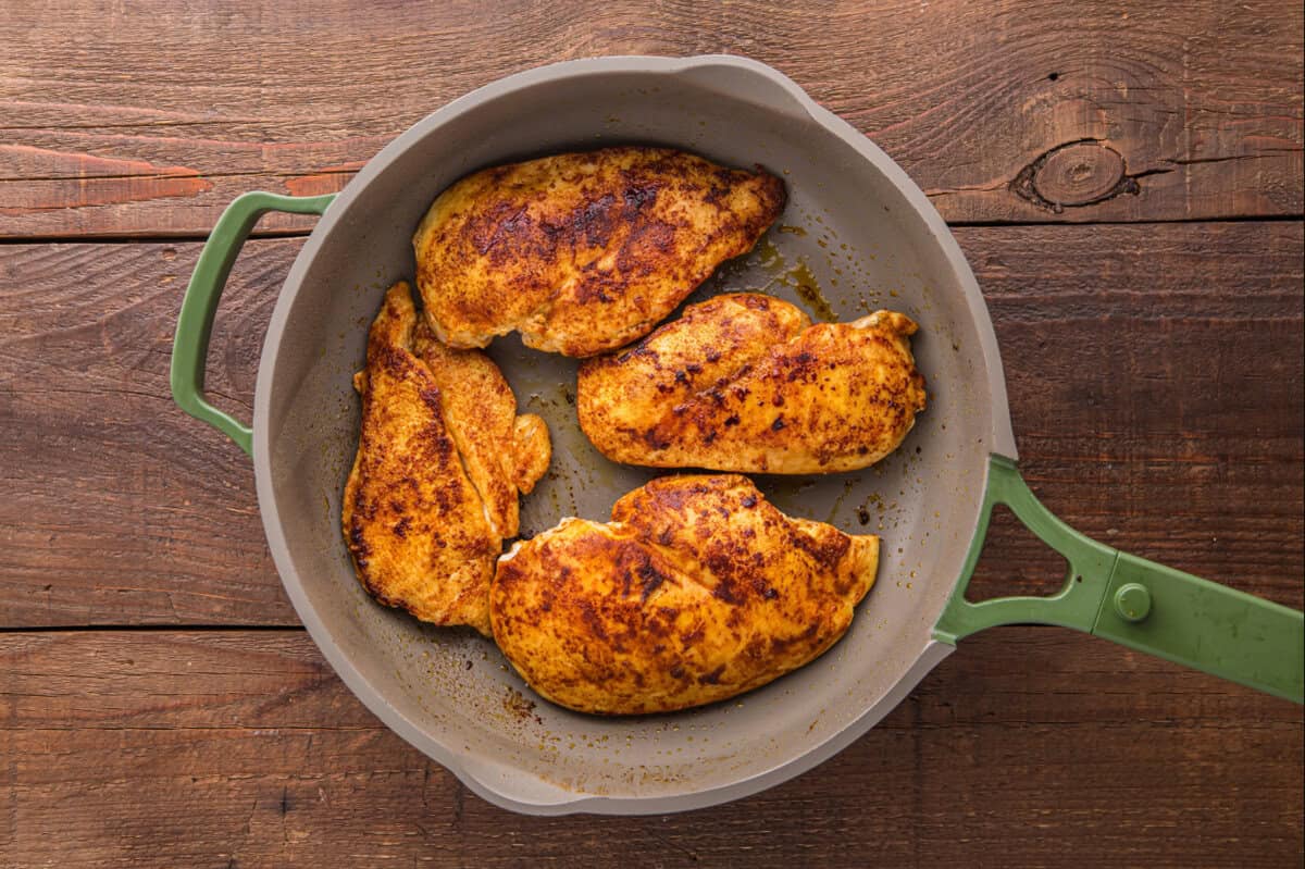 Browned chicken breasts in a skillet.