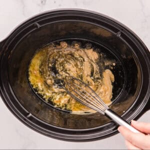 Whisking together ingredients in a Crockpot.