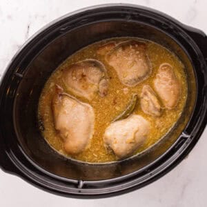 Cooked chicken thighs in the sauce.