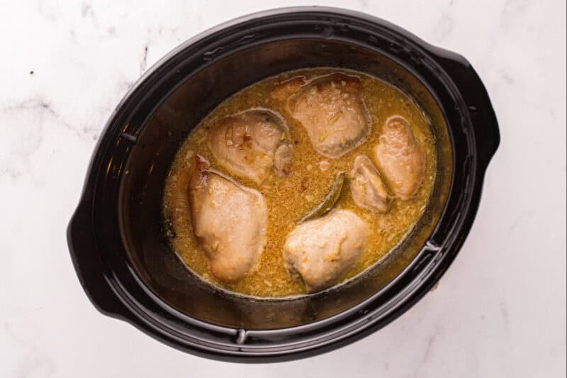 Cooked chicken thighs in the sauce.