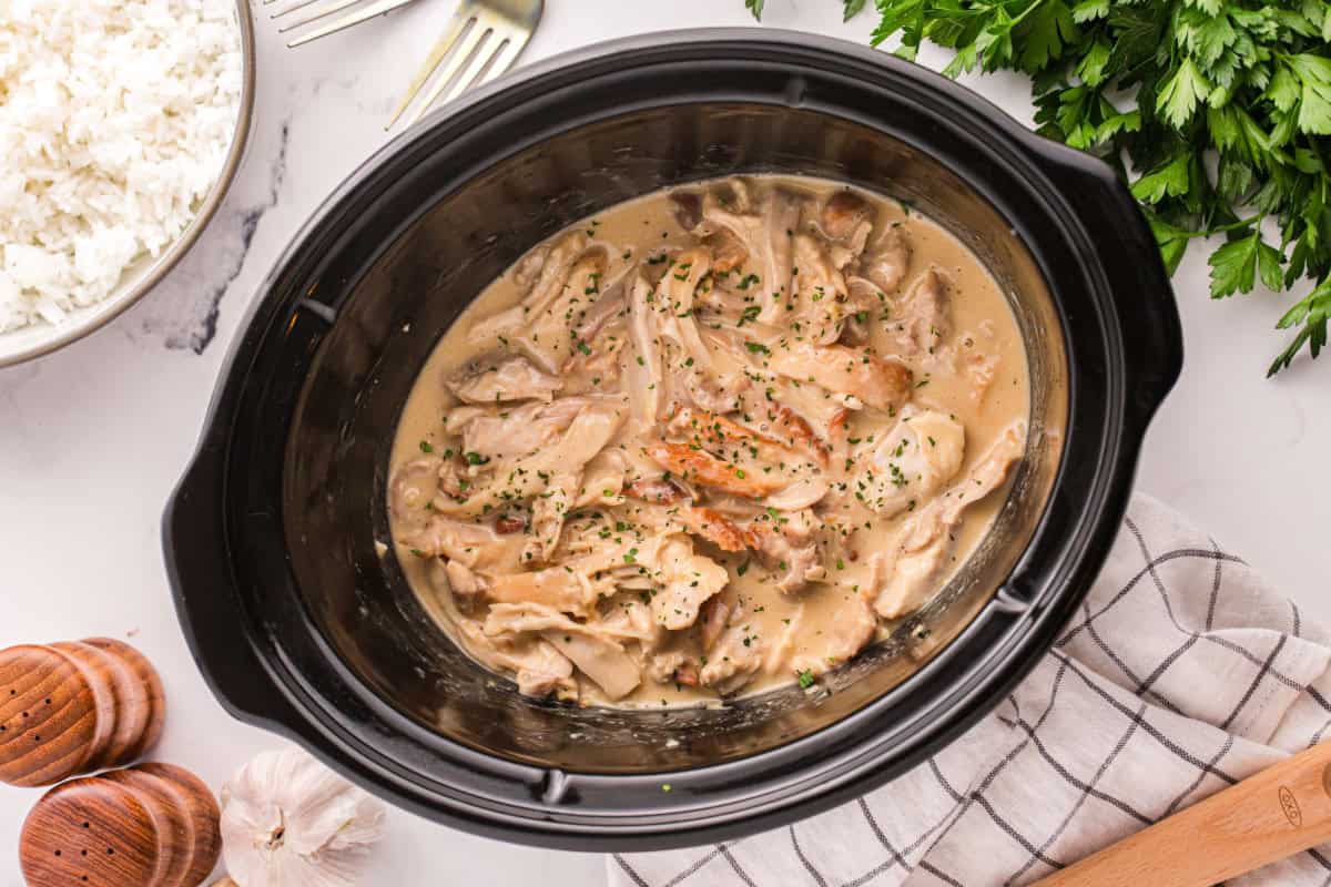 Shredded honey mustard chicken in a slow cooker.