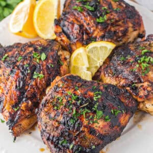 Marinated grilled chicken thighs on a plate.