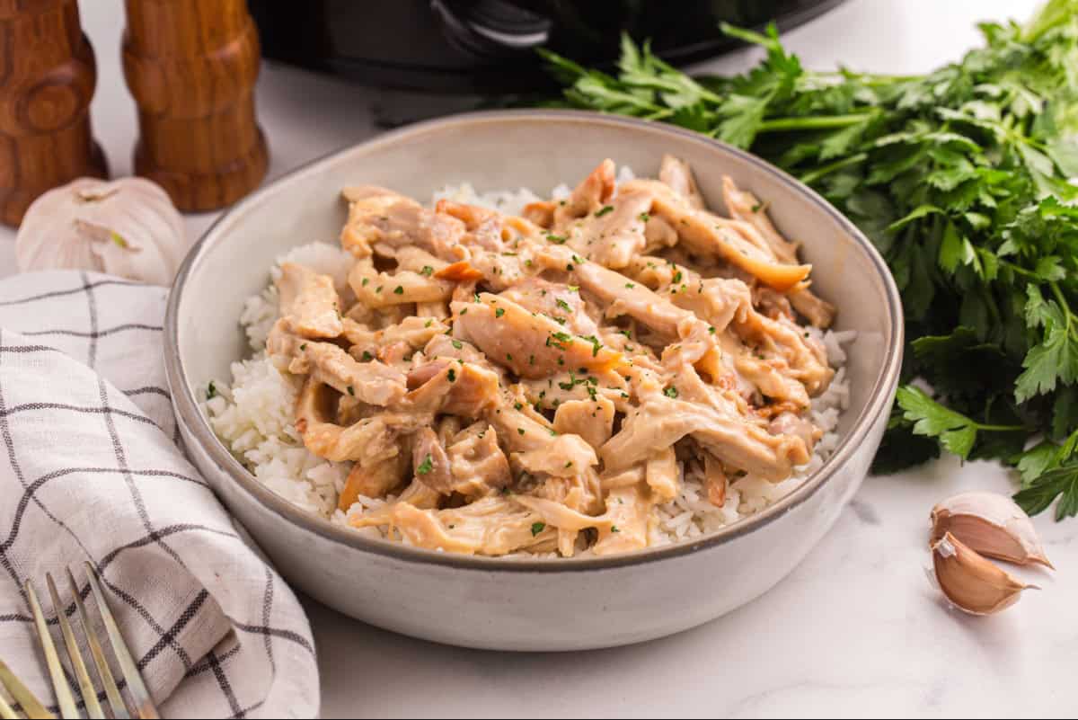 Shredded honey mustard chicken thighs served in a bowl of rice.
