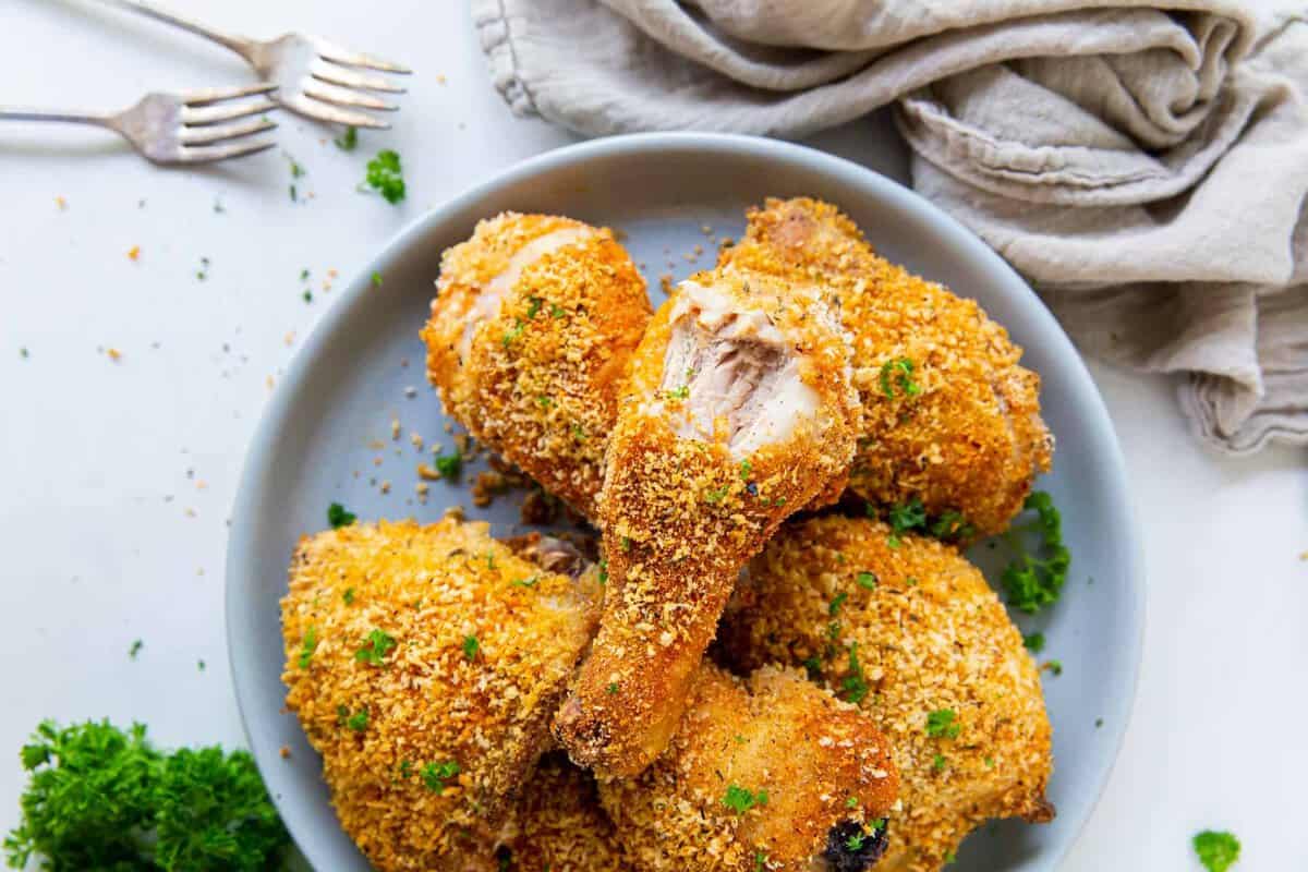 a plate of shake and bake chicken things and drumsticks
