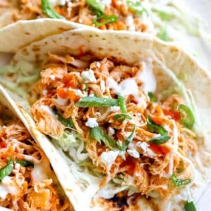 Buffalo shredded chicken tacos topped with ranch.