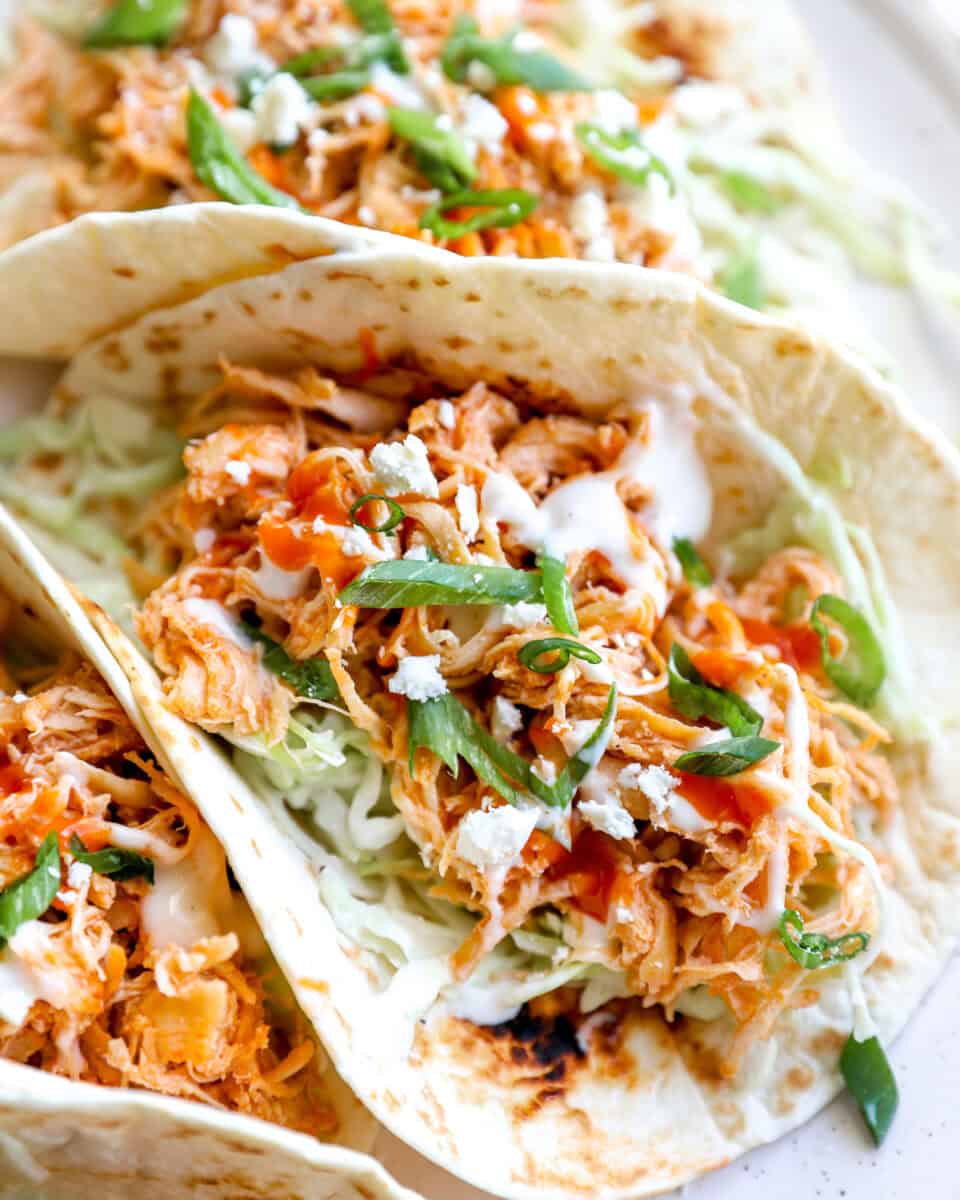 Buffalo shredded chicken tacos topped with ranch.