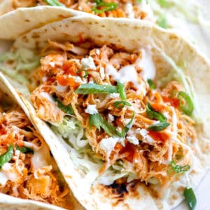 A buffalo chicken taco with shredded cabbage and dressing.