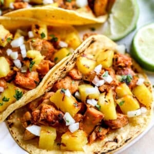 Marinated chicken al pastor served as tacos with pineapple and lime.