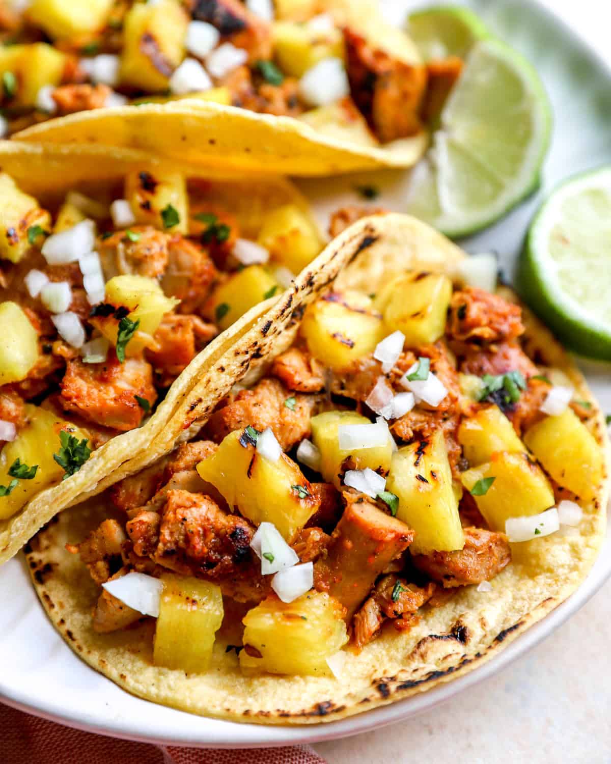 Marinated chicken al pastor served as tacos with pineapple and lime.