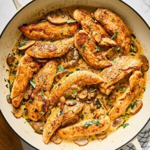 Tarragon chicken tenders cooked in a skillet.