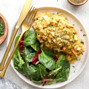 Chicken cordon bleu served on a plate with a green salad.
