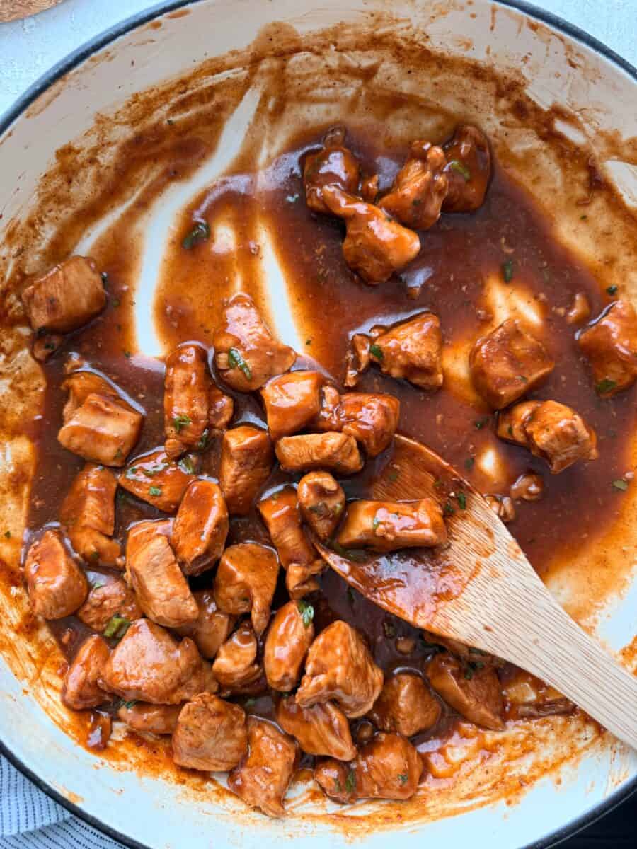 Bites of chicken in a pan with thickened diet soda sauce.
