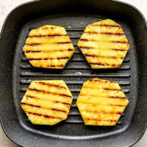 Cooking 4 rings of pineapple in a griddle pan.