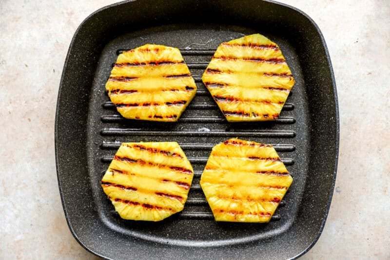 Cooking 4 rings of pineapple in a griddle pan.