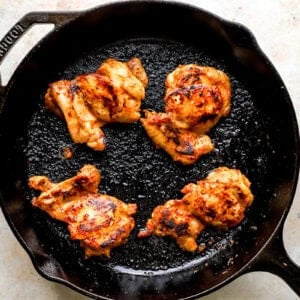 Chicken being cooked in a skillet.