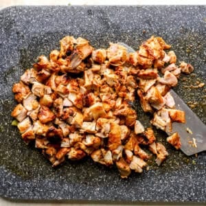 Chicken thighs cut into pieces on a chopping board.