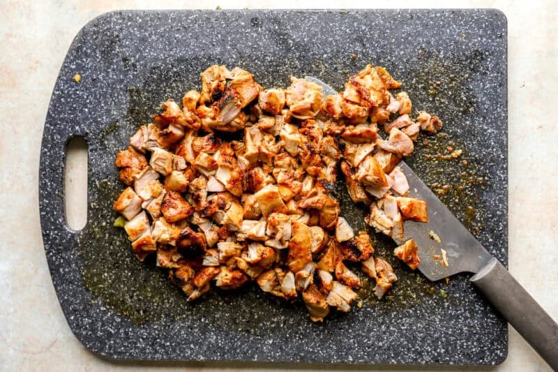 Chicken thighs cut into pieces on a chopping board.