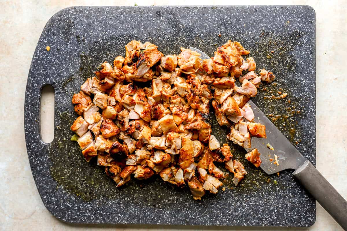 Chicken thighs cut into pieces on a chopping board.
