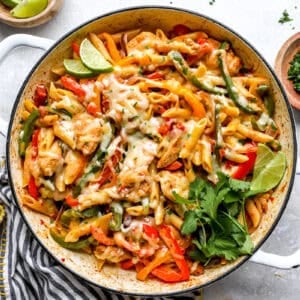 Chicken fajita pasta with cilantro and lime garnish.