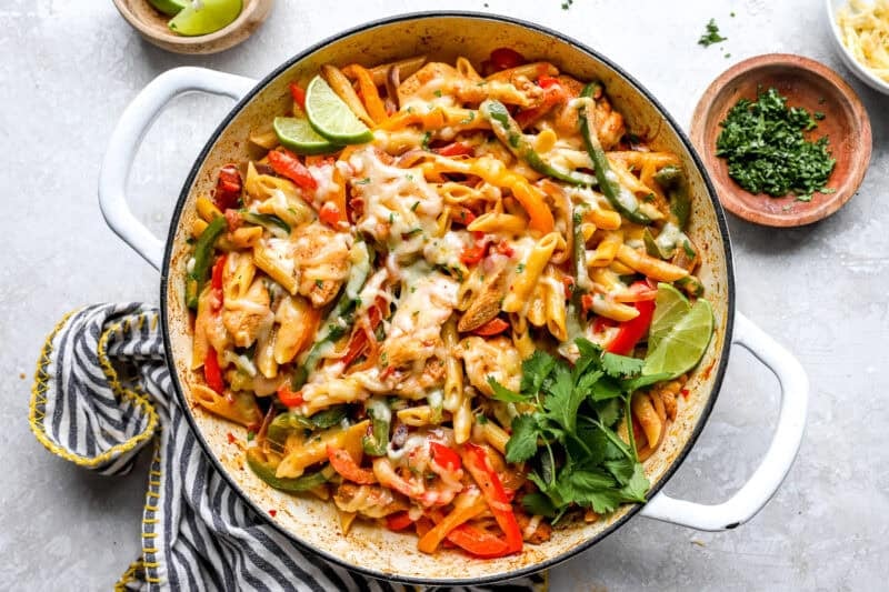 Chicken fajita pasta with cilantro and lime garnish.