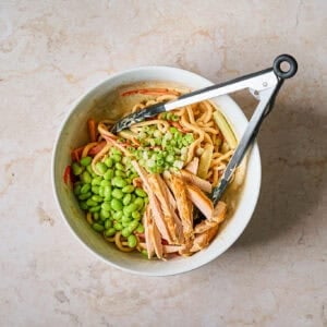 Tossing the ingredients for the salad together in a bowl.