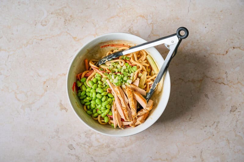 Tossing the ingredients for the salad together in a bowl.