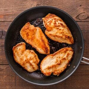 Browned chicken breasts in a skillet.