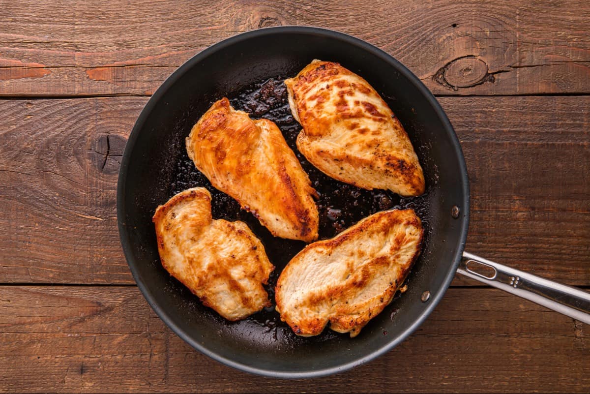 Browned chicken breasts in a skillet.