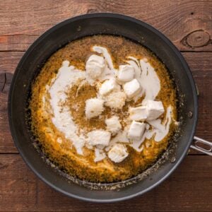 Cream and cream cheese stirred into chicken broth in the skillet.