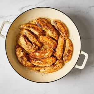 Browned chicken tenders in a skillet.