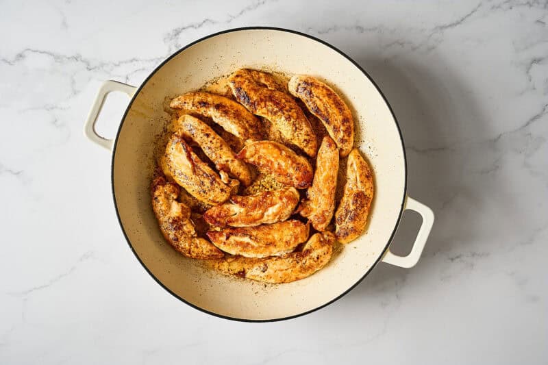 Browned chicken tenders in a skillet.