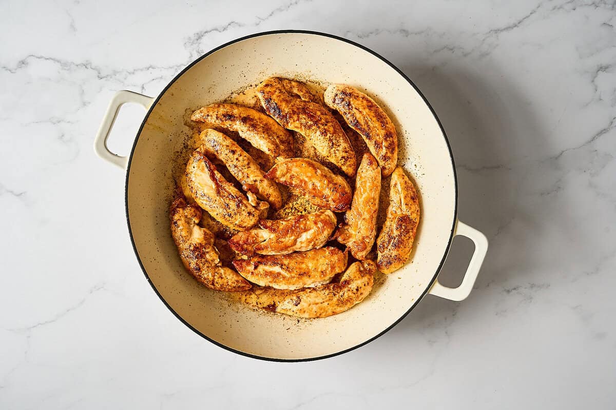 Browned chicken tenders in a skillet.