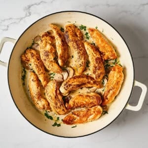 Chicken tenders added to the mushrooms and cream in the skillet.