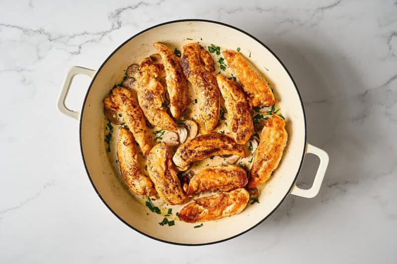 Chicken tenders added to the mushrooms and cream in the skillet.