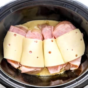 Cheese and ham on top of chicken breasts.