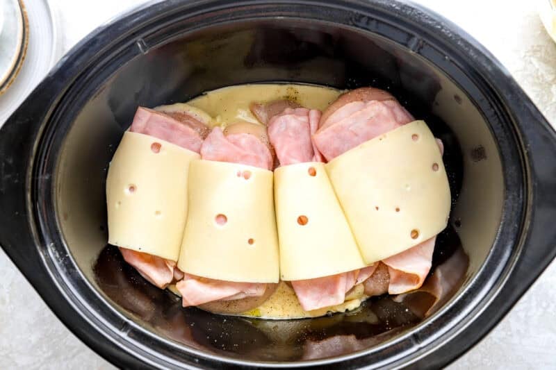 Cheese and ham on top of chicken breasts.