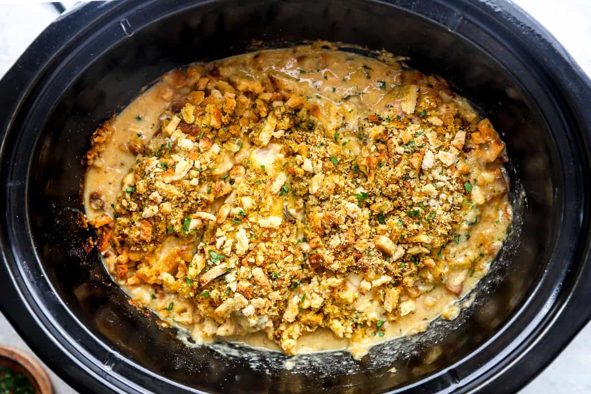 Cooked Crockpot chicken cordon bleu topped with stuffing.