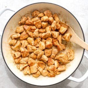 Browned chicken pieces in a skillet.