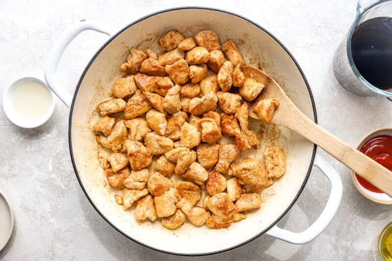 Browned chicken pieces in a skillet.