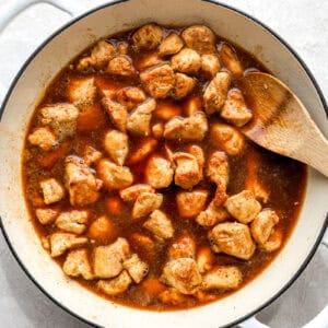 Cubes of chicken cooking in a diet soda sauce.