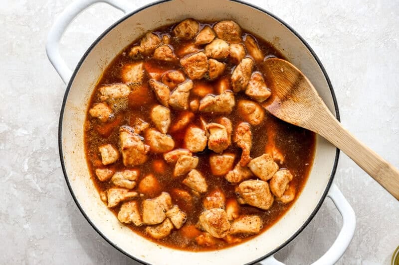 Cubes of chicken cooking in a diet soda sauce.
