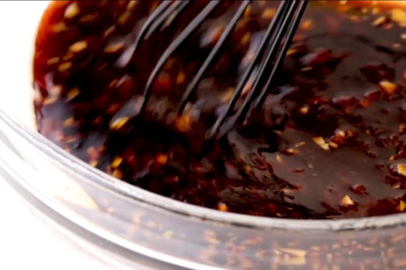 Whisking huli huli sauce in a bowl.