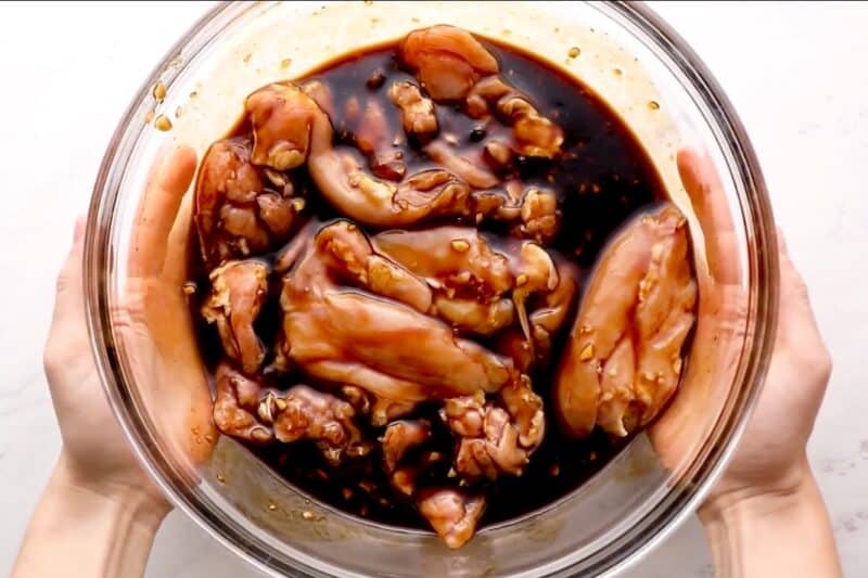 Marinating chicken thighs in a bowl.
