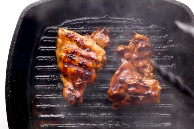 Flipping chicken as it cooks on the grill.