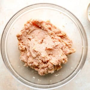 Ingredients for chicken meatballs combined in a bowl.
