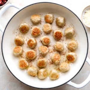 Browned meatballs in a skillet.
